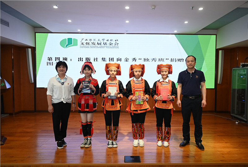 廣西師范大學(xué)出版社集團副總裁、工會(huì )主席莫曲波（右一）代表出版社向金秀“獨秀班”同學(xué)贈送圖書(shū)（李顯楊攝）.jpg