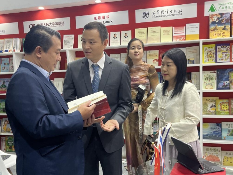 泰國書(shū)商和出版商協(xié)會(huì )主席蘇維奇（左一）在翻閱《近鏡頭：溫暖的瞬間》。（盧雯 攝）jpg_副本.jpg