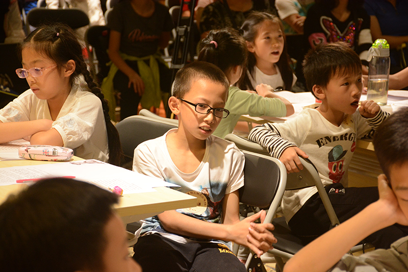 1528182664148201.jpg 小朋友們認真地聽(tīng)著(zhù)大學(xué)生領(lǐng)讀者講述《山海經(jīng)》的故事(鄧超穎 攝).JPG