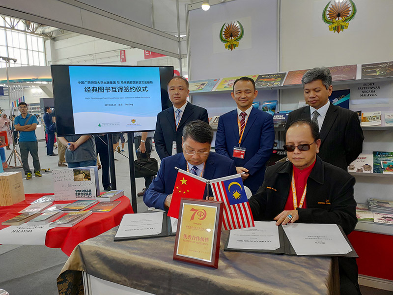 廣西師范大學(xué)出版社集團黨委書(shū)記、董事長(cháng)張藝兵（左前一）與馬來(lái)西亞國家語(yǔ)文出版局理事長(cháng)Datuk Abang Sallehuddin Abang Shokeran簽訂合約（陳子鋒攝）.jpg