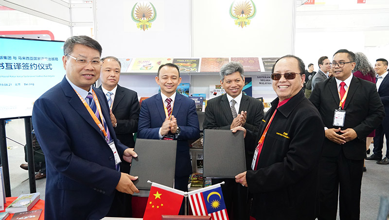廣西師范大學(xué)出版社集團黨委書(shū)記、董事長(cháng)張藝兵（左前一）與馬來(lái)西亞國家語(yǔ)文出版局理事長(cháng)Datuk Abang Sallehuddin Abang Shokeran交換簽約文件（陳子鋒攝）.jpg