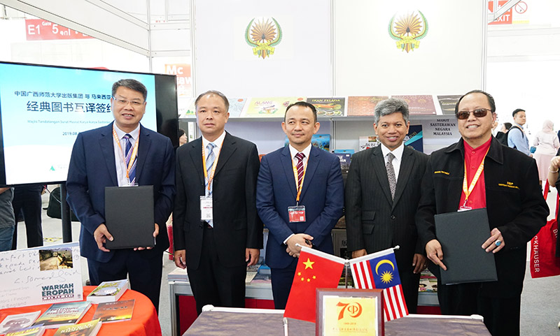 簽約儀式合影（左起：廣西師大出版社集團黨委書(shū)記、董事長(cháng)張藝兵，廣西師范大學(xué)黨委副書(shū)記趙鐵，馬來(lái)西亞教育部部長(cháng)Dr. Maszlee Malik，馬來(lái)西亞駐華大使RajaDato’ Nushirwan Zainal Abidin，馬來(lái)西亞國家語(yǔ)文出版局理事長(cháng)Datuk Abang Sallehuddin Abang Shokeran）.jpg